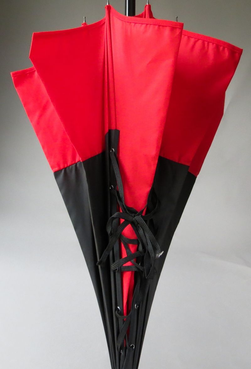Parapluie de luxe Chantal Thomass long rouge surmonté d'un corset noir, élégant et très féminin