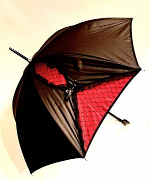 Parapluie Chantal Thomass long noir à noeud et dentelle noire sur fond rose, Gothique chic & anti vent